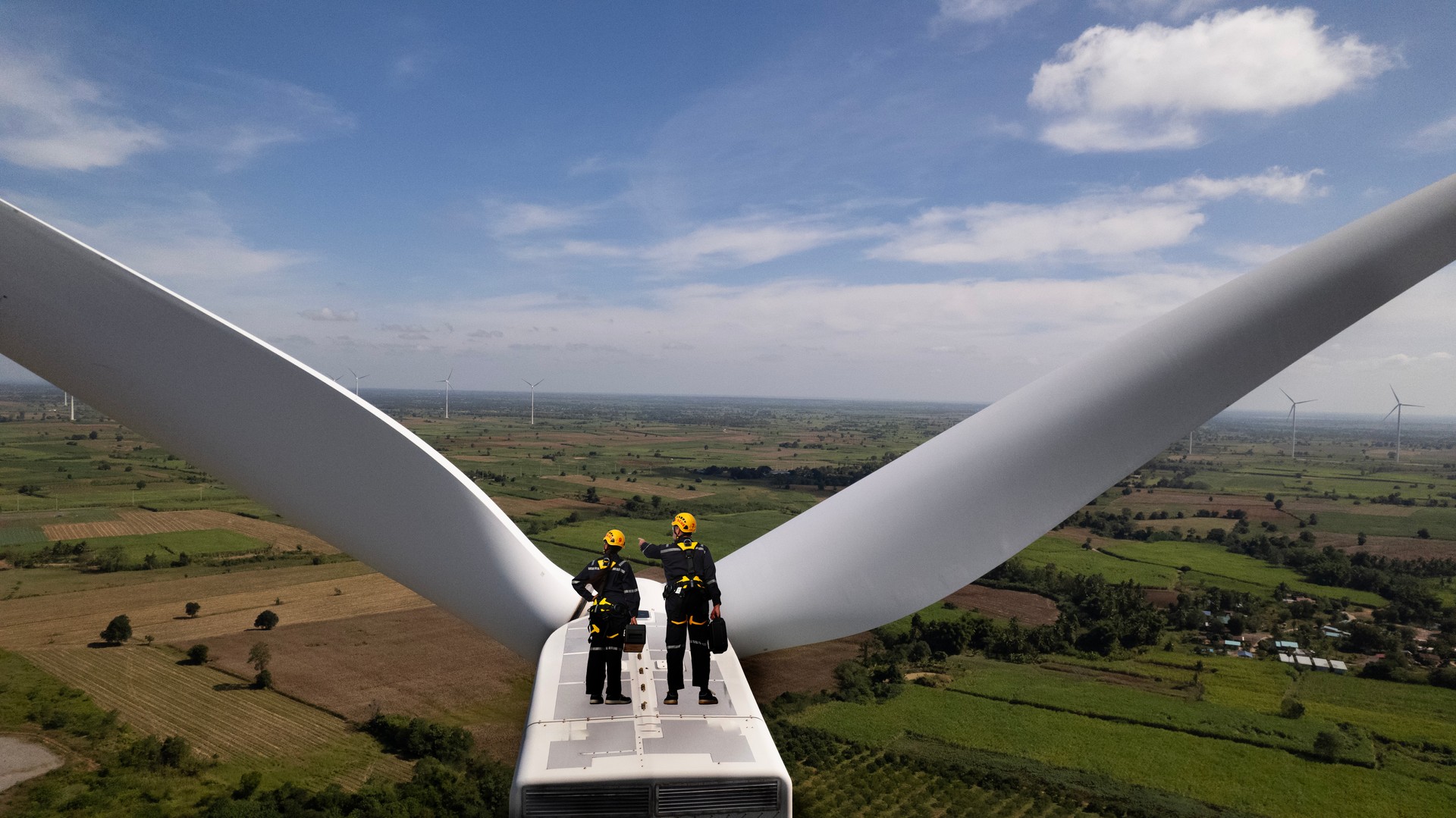 Senior and Specialist Wind turbine maintenance team working on top with the turbine  motor power stands, Green and reviewable energy concept